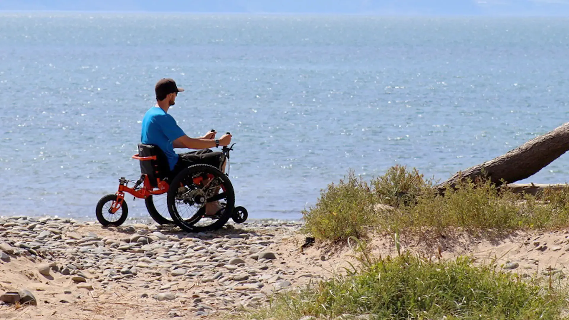 A person in a motorised wheelchair explores an accessible beach, enjoying nature with support from our non-profit CIC for disabled outdoor access.