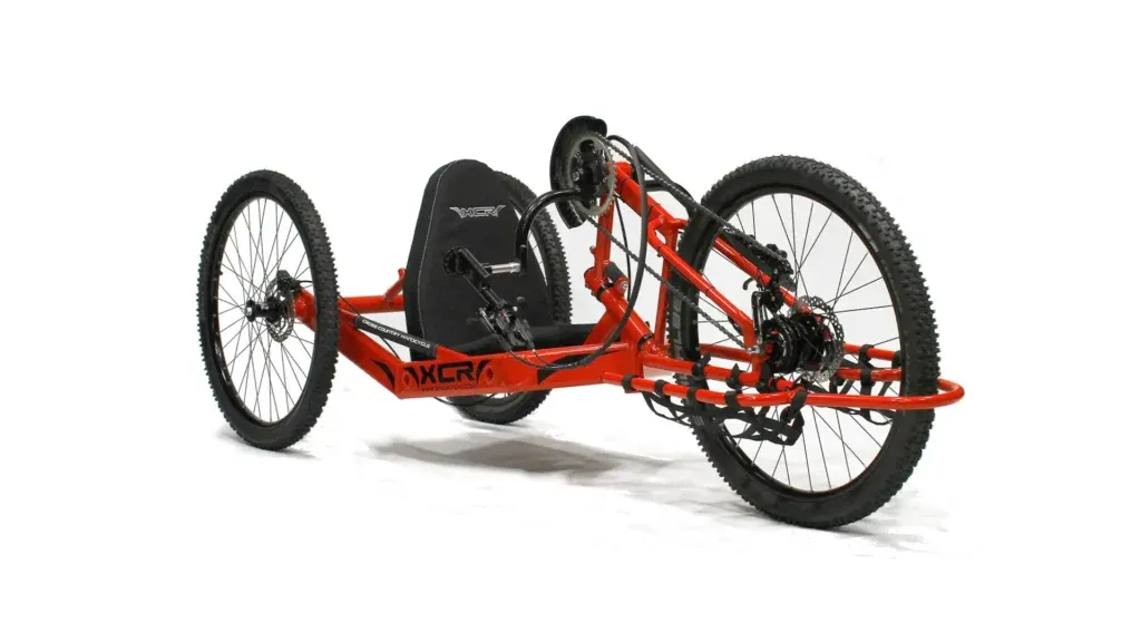 Adaptive red three-wheeled off-road handcycle for disabled people, enabling access to nature with our not-for-profit outdoor activities.