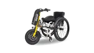 Clip-on Power Attachments 5 Manual wheelchair with yellow/black electric attachment for powered mobility, enabling outdoor access for disabled users in community activities.